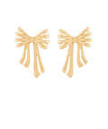 Gold-tone metal bow statement earrings with flowing ribbon detail displayed on a white background from The Pink Doxie Boutique.