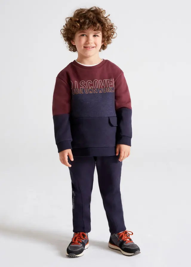 Child wearing the burgundy and navy Mayoral sweatshirt and jogger set