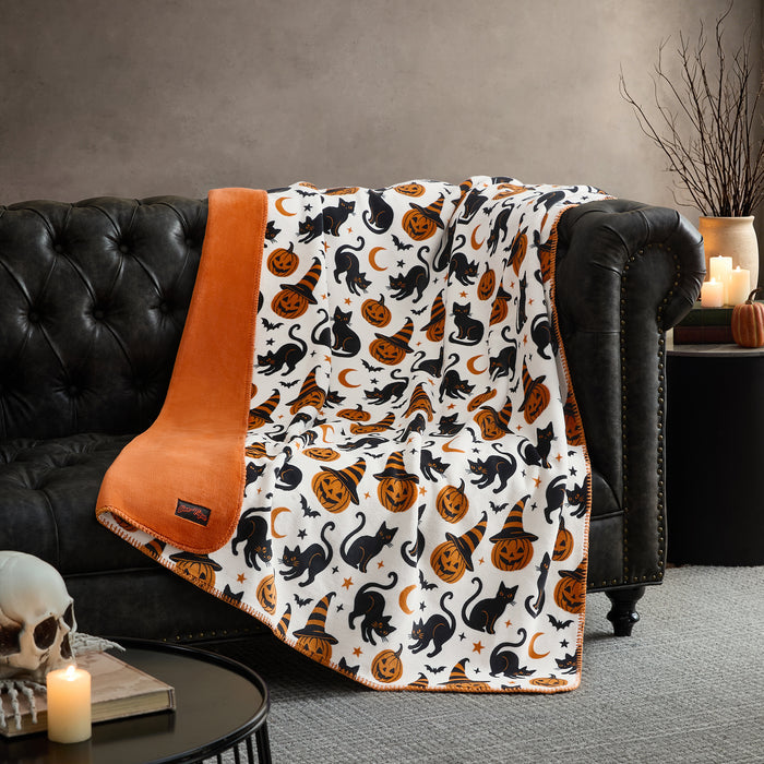 Manta Halloween Cats Night colocada sobre un sofá #color_UNB Cats Night
