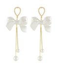 White pearl bow long tail earrings with crystal accents and dangling faux pearl drops from The Pink Doxie Boutique.