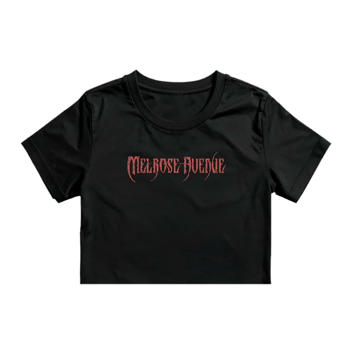 A black Melrose Avenue crop tee by ASColour 4062, made from 100% combed cotton, features bold red gothic-style "MELROSE AVENUE" lettering on the front.